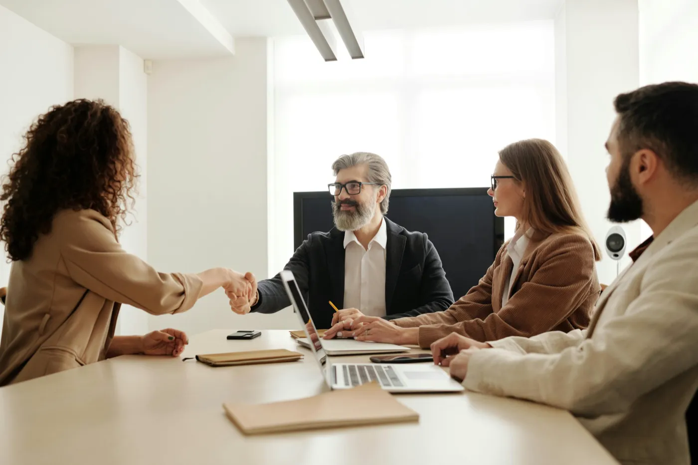 A handshake across the table at the start of a client meeting