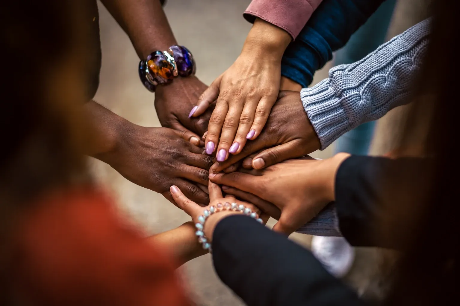 Several people stacking their hands together in a circle